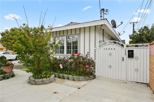 view of home's exterior with a gate, fence, and board and batten siding