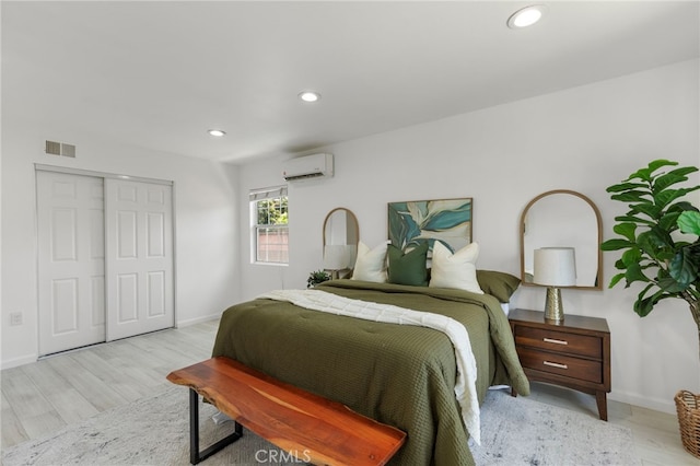 bedroom with a wall mounted air conditioner, visible vents, and baseboards