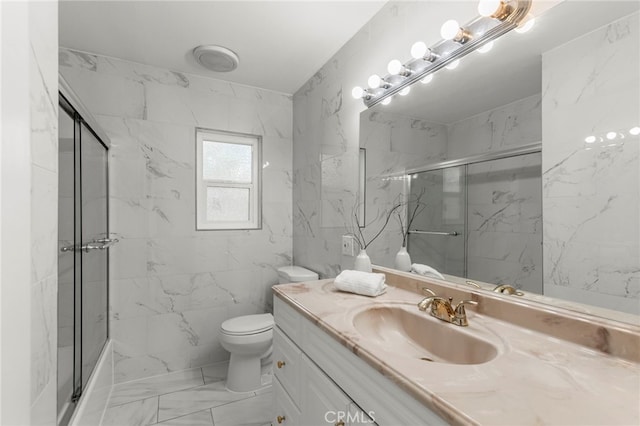 bathroom with marble finish floor, toilet, vanity, and a marble finish shower