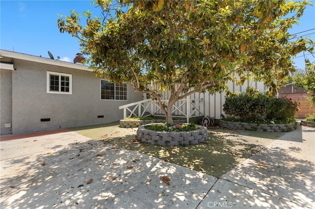 exterior space with a patio area, crawl space, and stucco siding