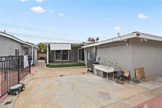 back of property featuring fence, a patio area, and stucco siding