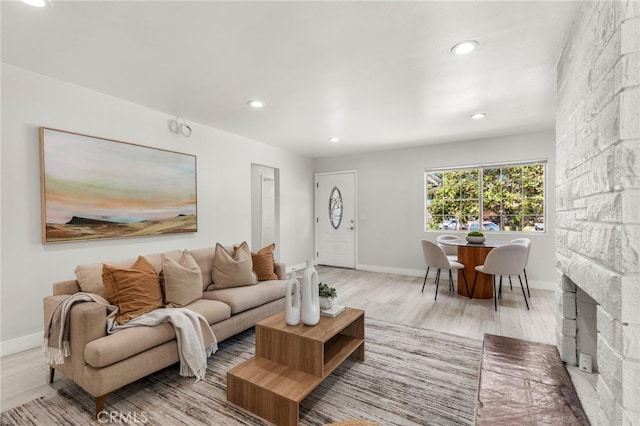 living room featuring light wood finished floors, baseboards, and recessed lighting