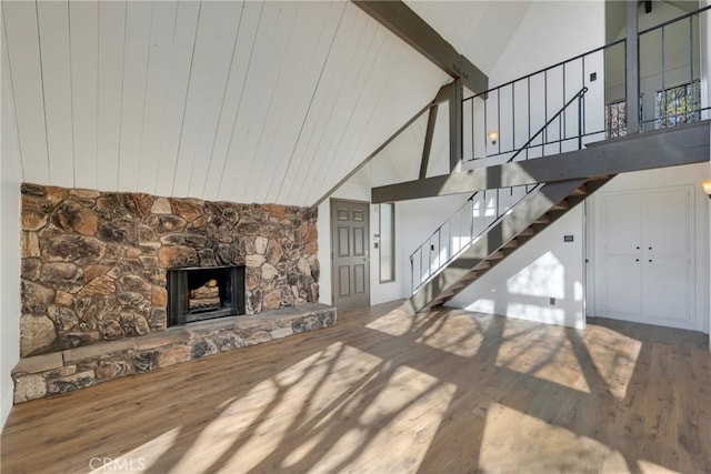 743 Rhine Rd, Lake Arrowhead, CA 92352 - unfurnished living room featuring a fireplace, beam ceiling, stairway, and wood finished floors