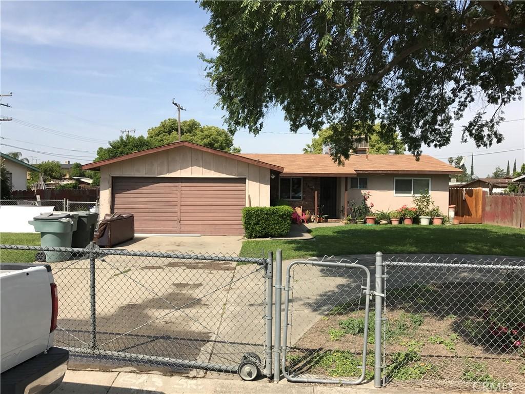 ranch-style house featuring a garage, a fenced front yard, a gate, and a front yard