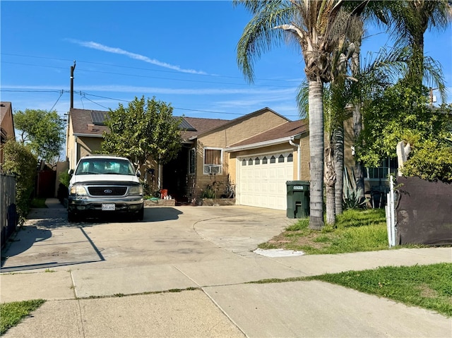 3509 Greenglade Ave, Pico Rivera, CA 90660 - view of front of house featuring concrete driveway, a garage, roof with shingles, and solar panels