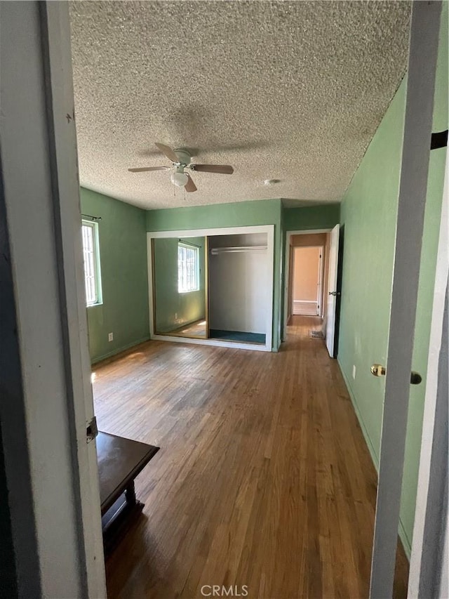 3509 Greenglade Ave, Pico Rivera, CA 90660 - unfurnished bedroom featuring wood finished floors, a textured ceiling, baseboards, a closet, and ceiling fan