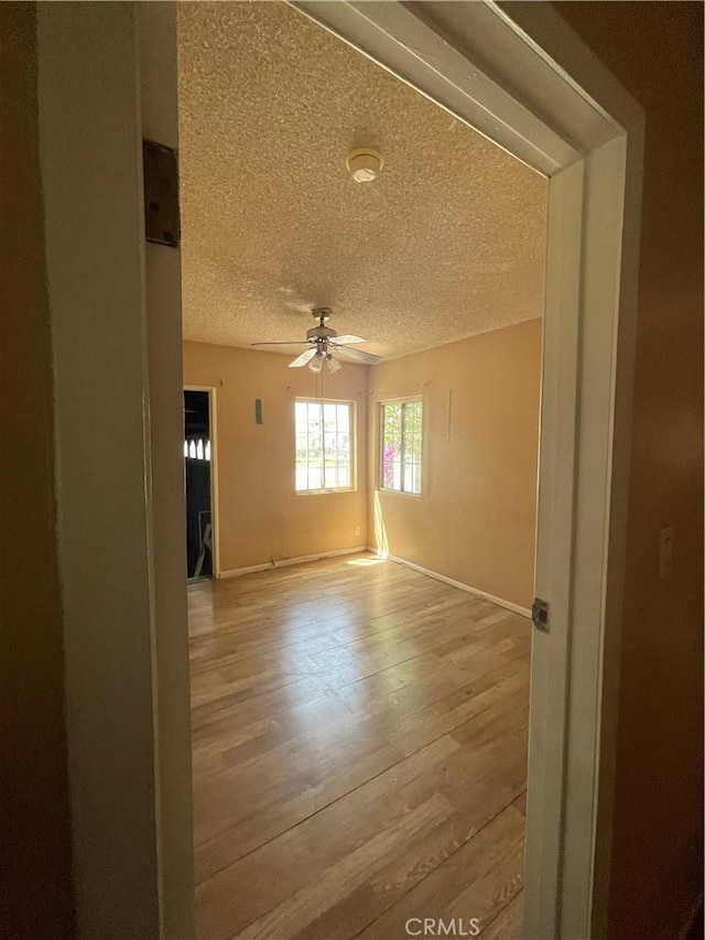 3509 Greenglade Ave, Pico Rivera, CA 90660 - empty room featuring a textured ceiling, light wood finished floors, ceiling fan, and baseboards