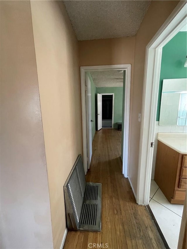 3509 Greenglade Ave, Pico Rivera, CA 90660 - hallway featuring a textured ceiling, light wood finished floors, and baseboards