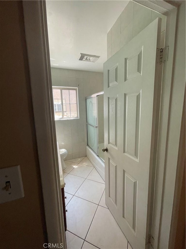 3509 Greenglade Ave, Pico Rivera, CA 90660 - bathroom featuring a shower with shower door, toilet, tile patterned floors, and tile walls