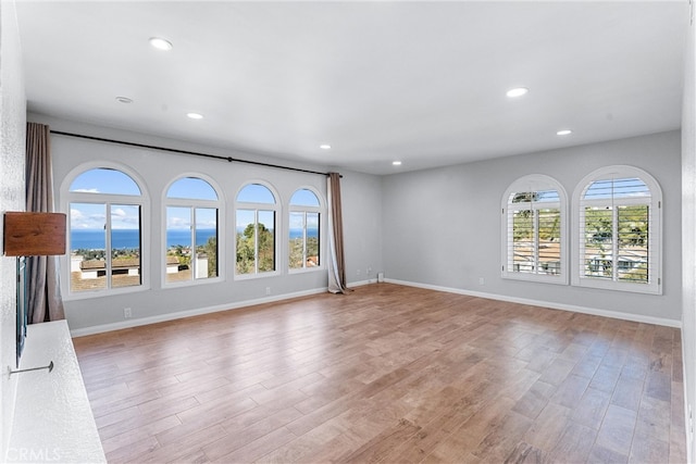 unfurnished living room featuring baseboards, light wood finished floors, and recessed lighting