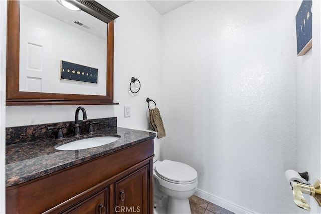 half bath featuring vanity, toilet, tile patterned floors, baseboards, and visible vents