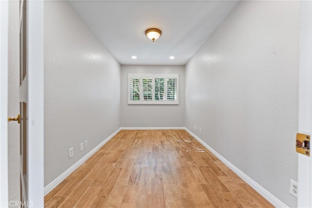spare room with baseboards, recessed lighting, and light wood-style flooring