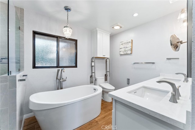 full bath with a soaking tub, toilet, a sink, and wood finished floors