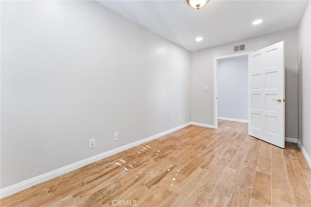 spare room featuring visible vents, light wood-style flooring, baseboards, and recessed lighting