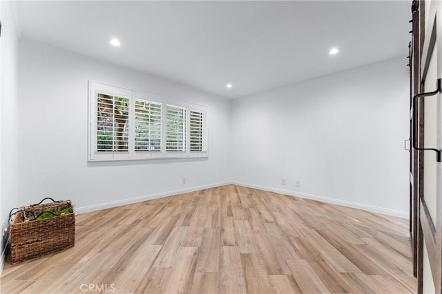unfurnished room with recessed lighting, light wood-style flooring, and baseboards