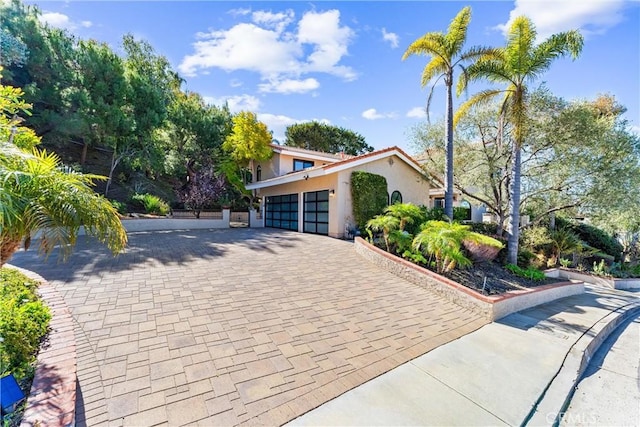 view of front facade with a garage, stucco siding, and driveway