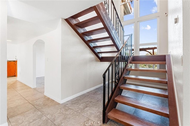 604 Avenida Acapulco, San Clemente, CA 92672 - stairs with arched walkways, baseboards, tile patterned flooring, and a textured wall