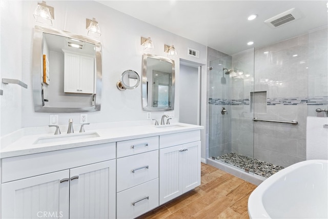 604 Avenida Acapulco, San Clemente, CA 92672 - full bath with tiled shower, double vanity, a freestanding bath, wood finished floors, and recessed lighting