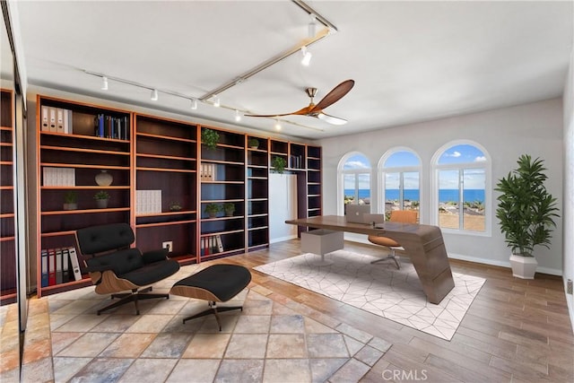 office space with track lighting, baseboards, ceiling fan, and wood finished floors