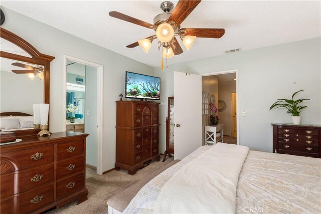 bedroom with baseboards, visible vents, a ceiling fan, and light colored carpet