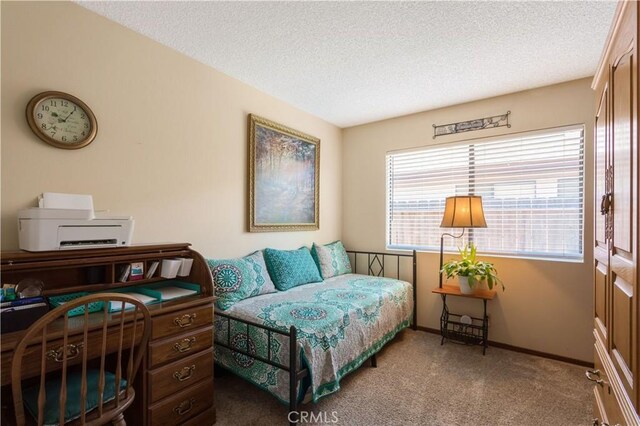 carpeted bedroom featuring a textured ceiling and baseboards
