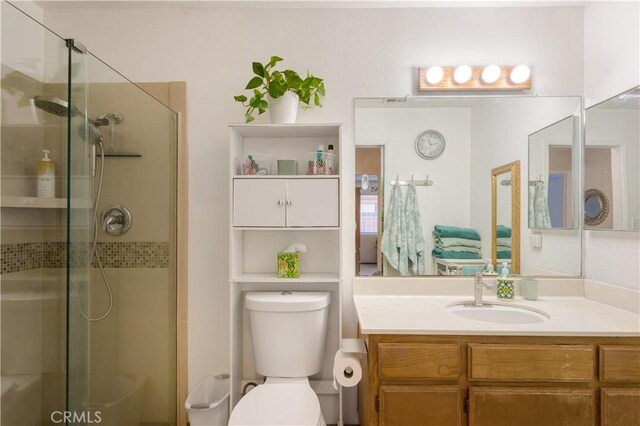 full bathroom with vanity, a shower stall, and toilet