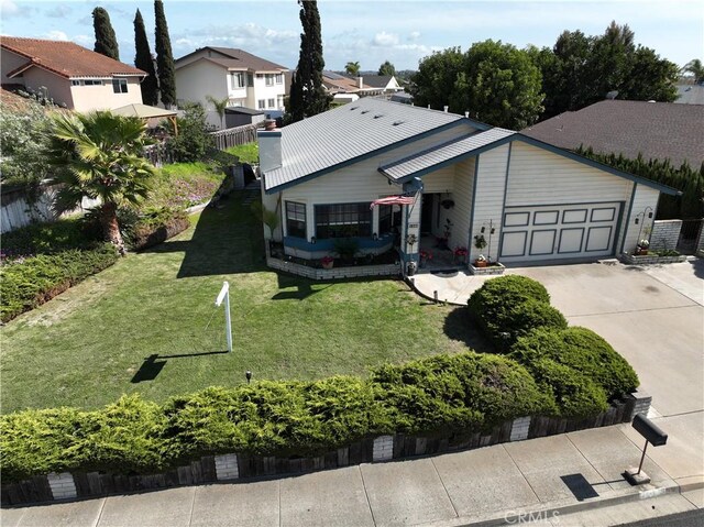 ranch-style house with a garage, a residential view, concrete driveway, and a front yard