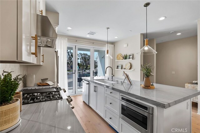 19011 Main St Unit 121, Huntington Beach, CA 92648 - kitchen featuring white cabinets, a sink, stainless steel appliances, extractor fan, and light wood finished floors