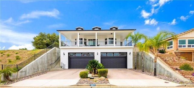 view of front facade featuring a balcony, fence, stairs, a garage, and concrete driveway