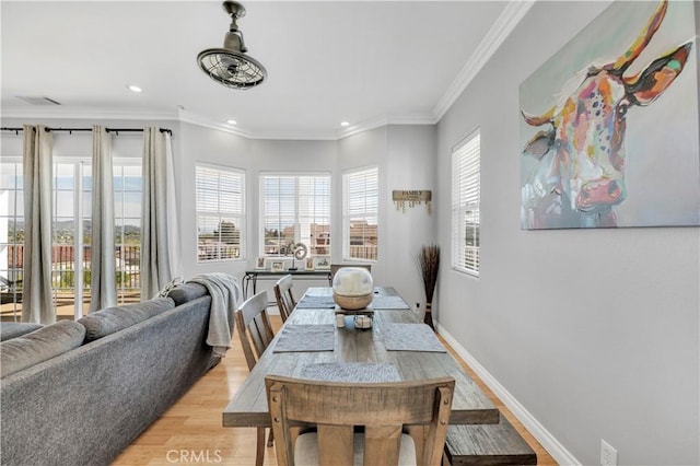 dining room with baseboards, ornamental molding, visible vents, and light wood-type flooring
