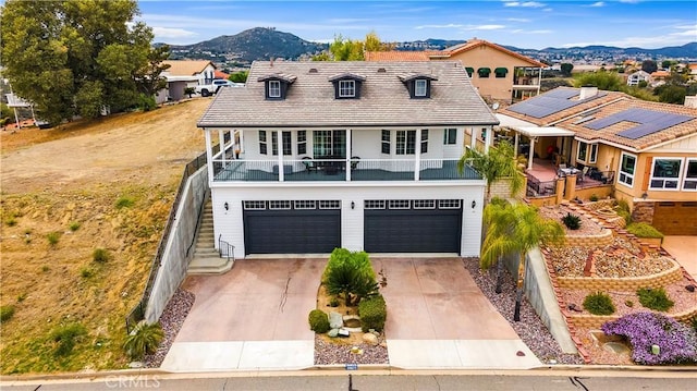 view of front facade featuring driveway, a mountain view, stairs, and an attached garage
