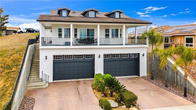 view of front facade with driveway, an attached garage, fence, and stairs