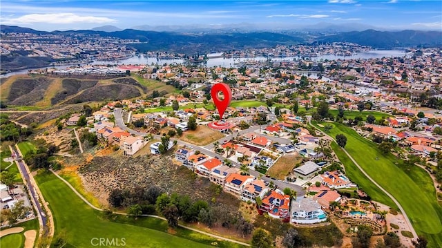 drone / aerial view with golf course view and a water and mountain view