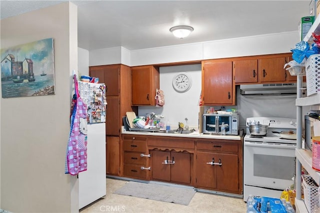 kitchen with white appliances, brown cabinets, under cabinet range hood, and a sink