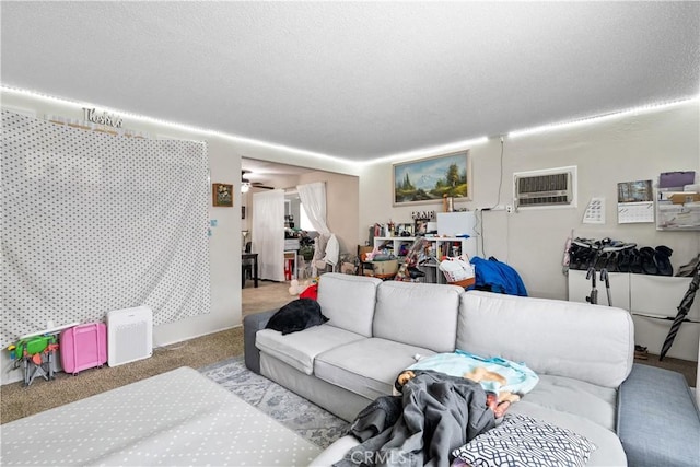 living room featuring a textured ceiling, an AC wall unit, ceiling fan, and carpet flooring