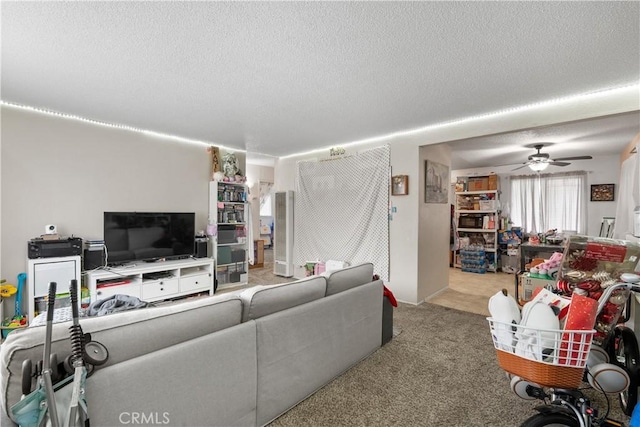 living area featuring a textured ceiling, ceiling fan, and carpet flooring