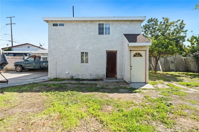 back of property with fence and stucco siding