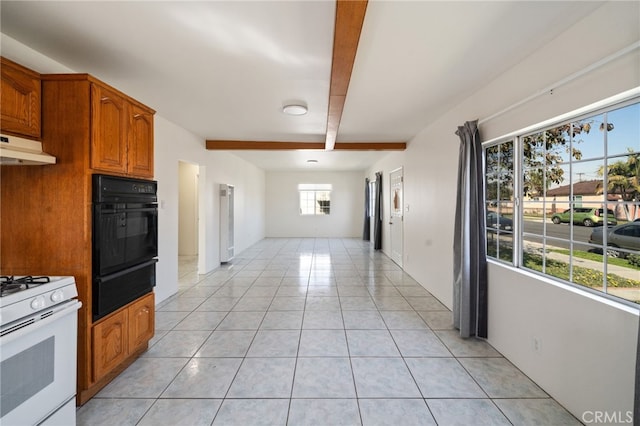 kitchen featuring light tile patterned floors, beamed ceiling, oven, white gas range oven, and a warming drawer
