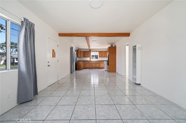 interior space with light tile patterned floors and beamed ceiling