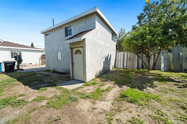 back of property featuring a patio area, stucco siding, and fence