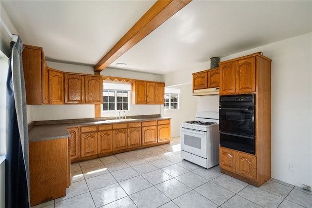kitchen with oven, white range with gas cooktop, brown cabinets, under cabinet range hood, and a sink