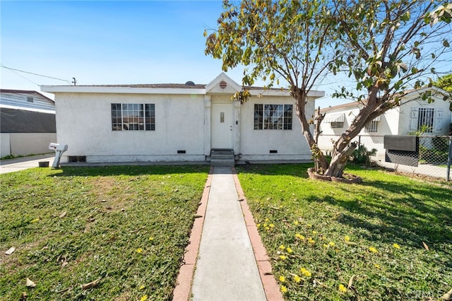 view of front facade featuring crawl space, a front lawn, and fence