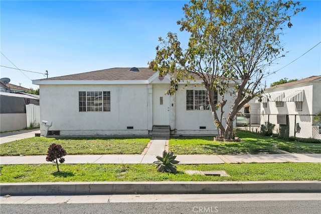 view of front facade with crawl space, a front yard, and fence
