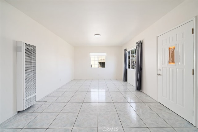 empty room with a heating unit and light tile patterned flooring