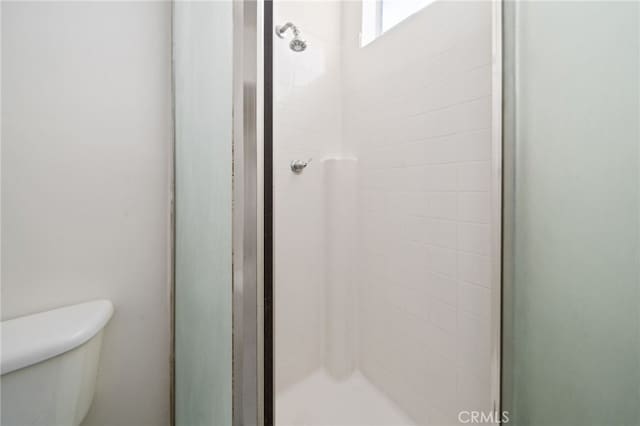 full bath featuring toilet and a stall shower