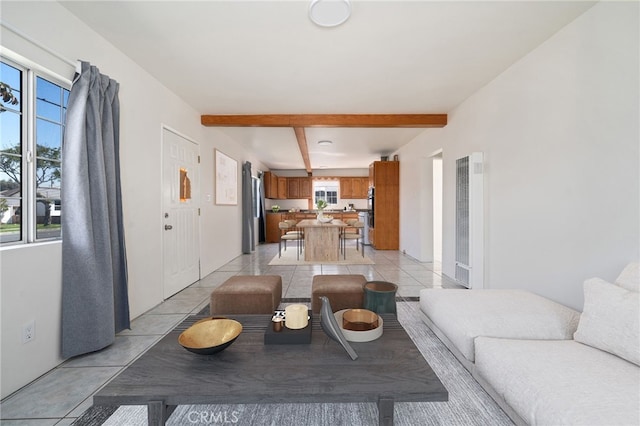 living area with beamed ceiling and light tile patterned flooring