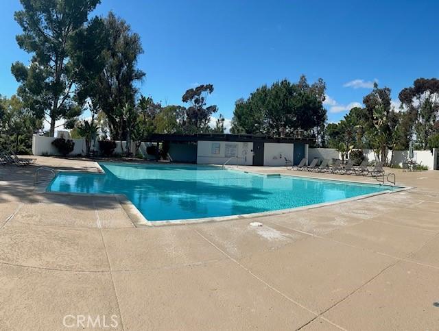 pool with a patio and fence
