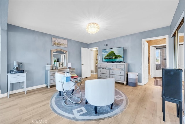 interior space with baseboards, light wood finished floors, and an inviting chandelier