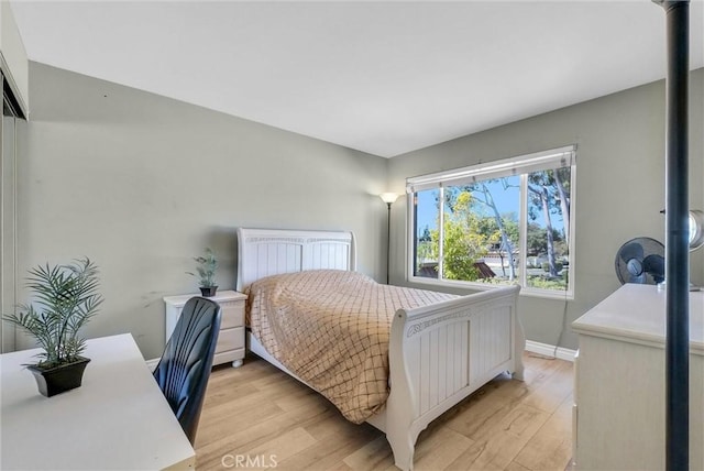 bedroom with baseboards and light wood finished floors
