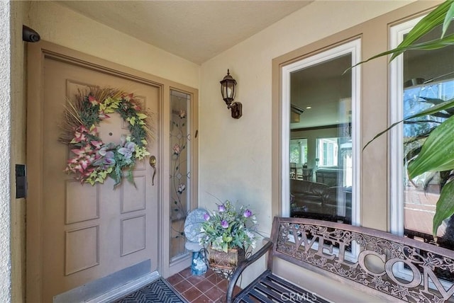 property entrance featuring covered porch and stucco siding